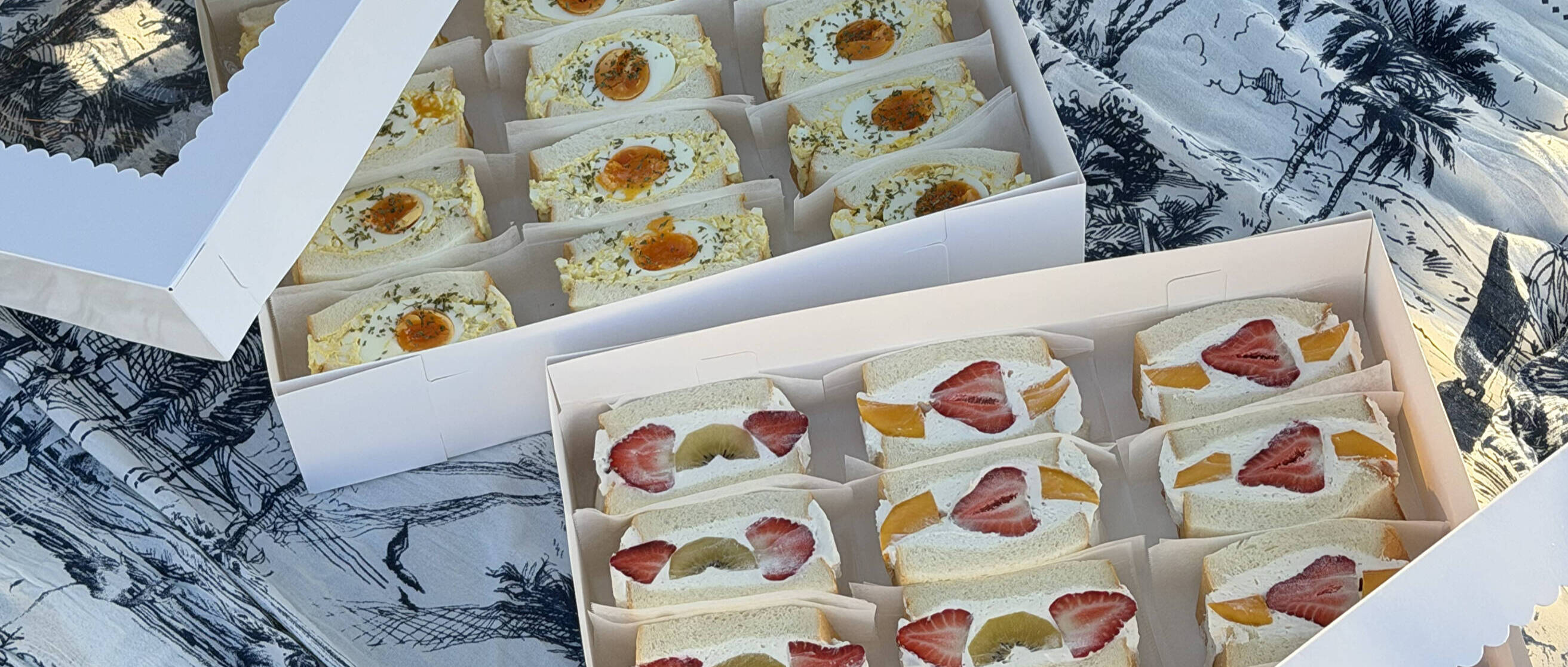 Kibako fruit and tamago sandos arranged in presentation boxes